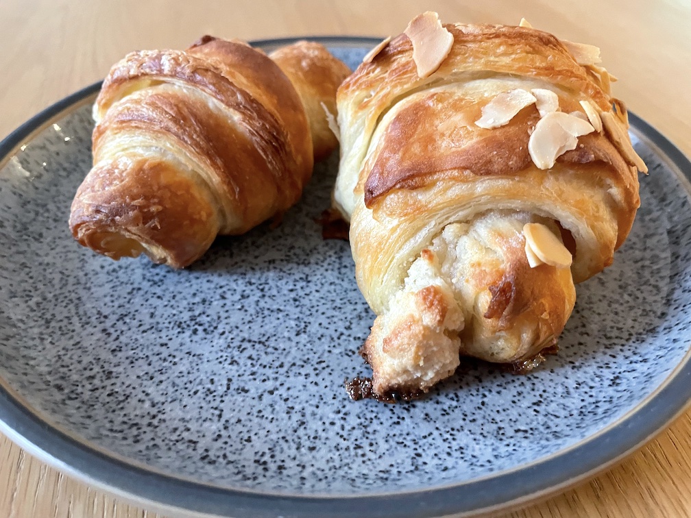 A plain croissant and an almond croissant